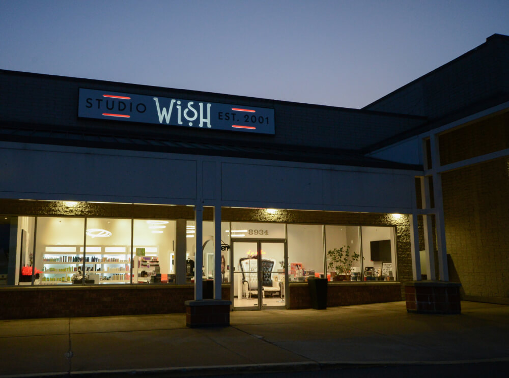 - Studio Wish Salon Spa, OH A storefront for Studio Wish, established in 2001, is lit up in the evening with visible interior lights and salon equipment inside. - Studio Wish Salon Spa, OH